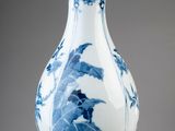 a blue and white vase sitting on top of a table
