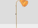 a gold floor lamp on a white surface with a white background