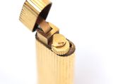 a close up of a gold lighter with a white background