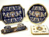 trois pièces en porcelaine décorées de bleu et d'or sur fond blanc