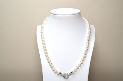 Un collier ras de cou en perles de culture avec fermoir sert…