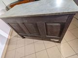 an old wooden cabinet with a marble top in a kitchen