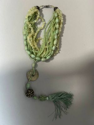 un collier orné de perles et d'un pompon qui y est suspendu