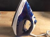 a blue and white iron sitting on a wooden table
