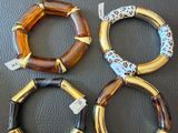 three bracelets of different colors and shapes on a black surface
