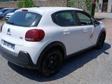 a small white car parked in a parking lot