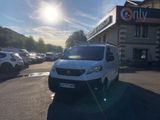 une petite camionnette blanche garée devant un bâtiment