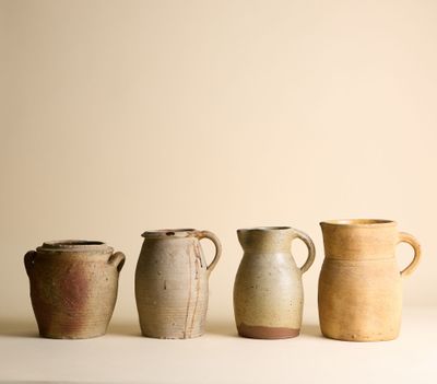 Plusieurs vases de différentes tailles sont alignés sur une surface blanche