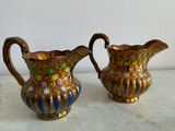 pair of gold and blue vases sitting on a marble counter top