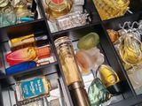 a drawer full of perfume bottles and other items