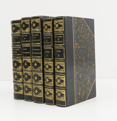 un lot de trois livres noirs ornés de dorures