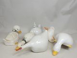 cinq canards blancs posés sur une surface blanche