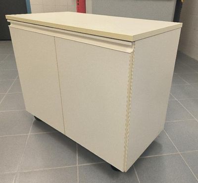 a white cabinet sitting on top of a tile floor