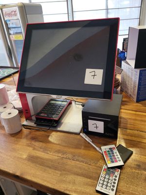 un bureau sur lequel se trouvent un écran, un clavier, une télécommande et d'autres objets
