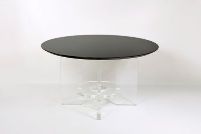 une image représentant une table avec un plateau noir et un piètement transparent