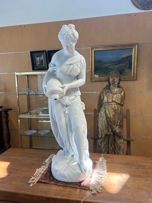 une statue de femme tenant un bébé sur une table