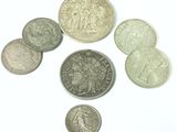 several coins are arranged in a circle on a white surface