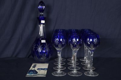 six verres à vin et une carafe posés sur une table