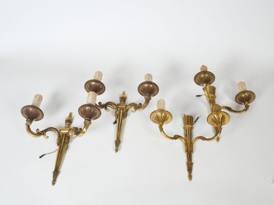 three brass wall sconces on a white background