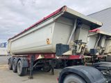 un camion-benne garé à côté d'un immeuble