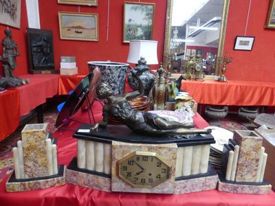 une table sur laquelle se trouvent une horloge, des bougies et une statue