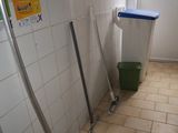 a bathroom with a trash can and a trash can on the floor