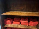 wooden shelves with red folded napkins stacked on top of each other