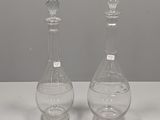 une paire de carafes en verre transparent posées sur une table blanche