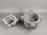 two cement pots sitting next to each other on a table