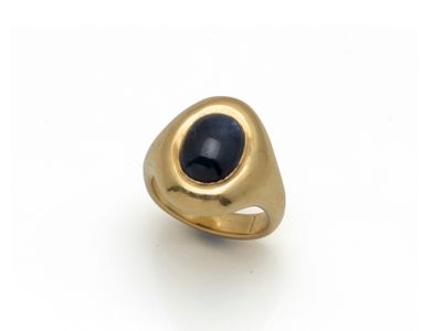 gros plan d'une bague en or avec une pierre noire