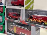 a lot of toy firetrucks in boxes on the table