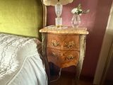 un lit avec une tête de lit verte, à côté d'une table de chevet sur laquelle est posée une lampe
