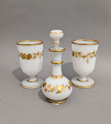 trois vases blancs et dorés posés les uns à côté des autres sur une surface grise