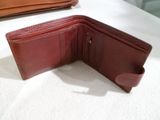 un portefeuille en cuir marron posé ouvert sur une table