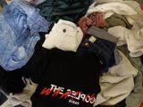 a pile of clothes that is sitting on a bed