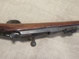 an old rifle with a wooden handle on a beige cloth