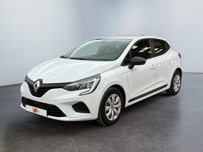 Une voiture blanche est garée dans une pièce au sol noir.
