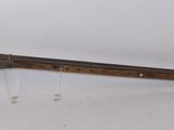 an old gun with a wooden handle on display on a white surface