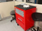 une photo représentant une armoire à outils et un tabouret dans un garage