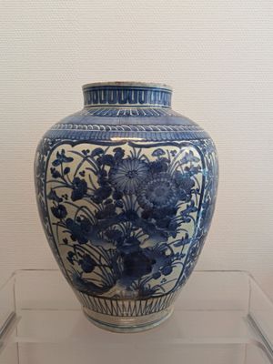 un vase bleu et blanc exposé dans une vitrine