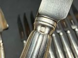 a lot of silverware on a table with a knife and fork