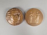 a close up of a coin on a white surface with a picture of a man