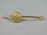 un gros plan d'une broche en or ornée d'un lion