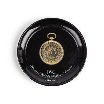 une image représentant une assiette noire ornée d'un médaillon doré
