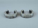 paire de boucles d'oreilles créoles en métal argenté ornées de perles noires sur fond gris