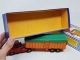someone is holding a box with a toy truck inside of it