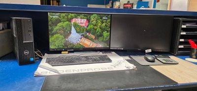 a computer desk with two monitors and a keyboard on it