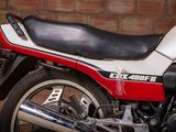 a red and white motorcycle parked in front of a brick wall