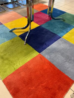 a multicolored rug on the floor in a room