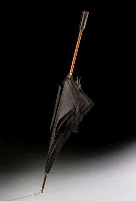 un parapluie à l'envers dans les airs, sur fond noir